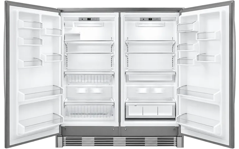 Interior de un congelador y un refrigerador instalados en pareja, con sus puertas abiertas y compartimentos vacíos
